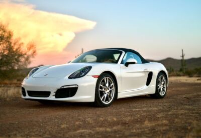 front angle shot of the Porsche Boxster facing left with a big cloudy sky in the background