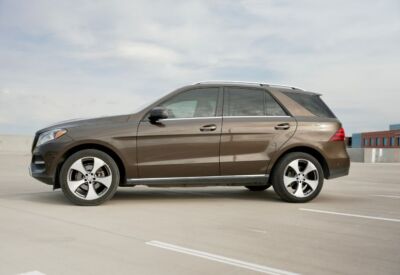 Side view of the Mercedes Benz GLE-Class facing left with a cloudy sky background